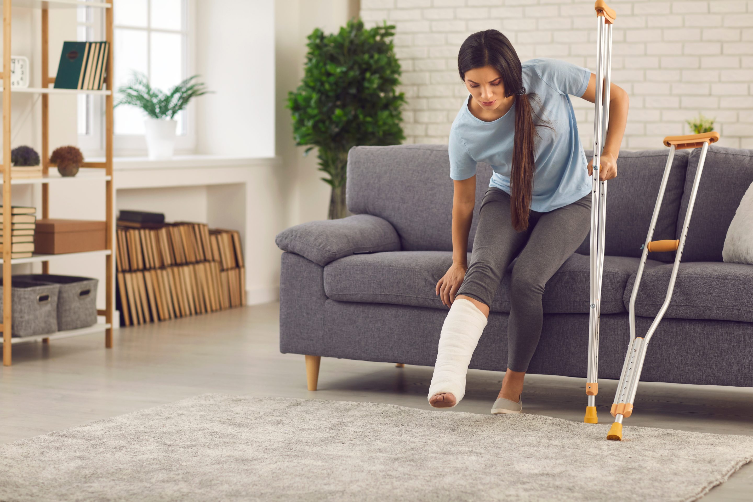 Young,Woman,With,Broken,Leg,In,Plaster,Cast,Trying,To Unfall